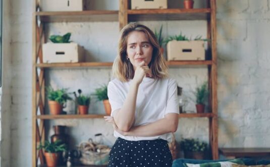A young woman with hand on chin looking thoughtful.