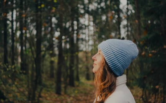 Woman in blue hat in autumn forest