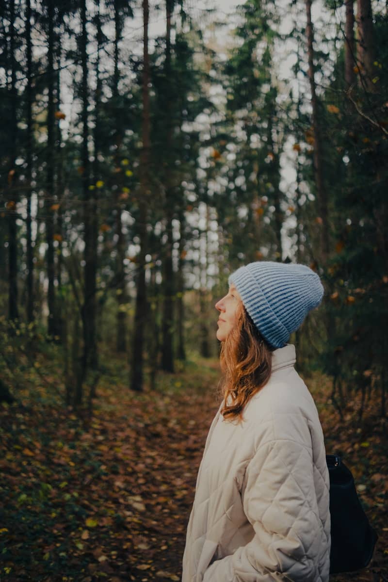 Woman in blue hat in autumn forest